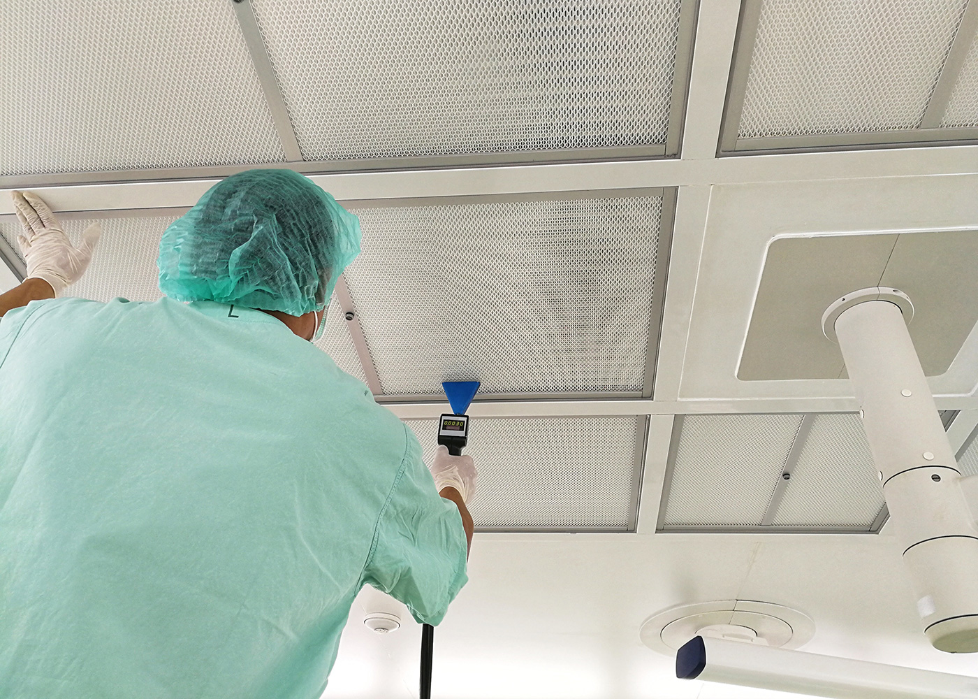 A technician scans and tests the filter performance in the ceiling of a cleanroom